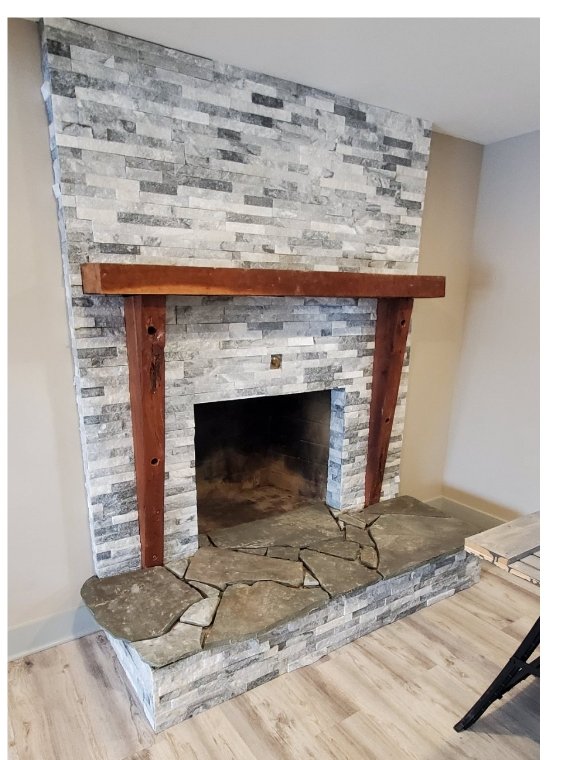 Stone fireplace with a timber mantel, completed by Blue Diamond Contractors